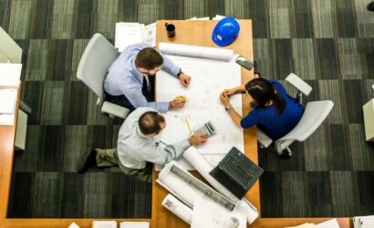 Top view of a team working on construction plans in an office setting.