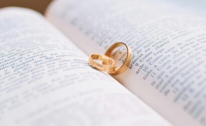 Close-up of wedding rings resting on the pages of an open book, symbolizing love and commitment.
