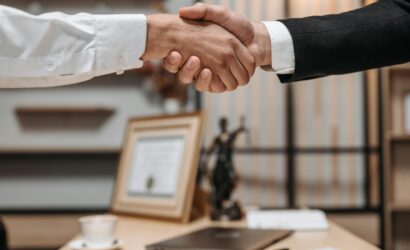 Close-up of a handshake between two professionals in a modern office setting, emphasizing partnership and agreement.