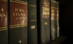 Detailed close-up of law and regulation books on a bookshelf, emphasizing education and knowledge.