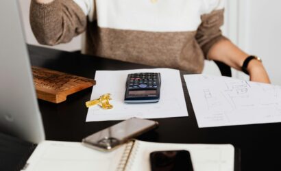 A business desk setup with a calculator, papers, and a keyboard, reflecting a work environment.