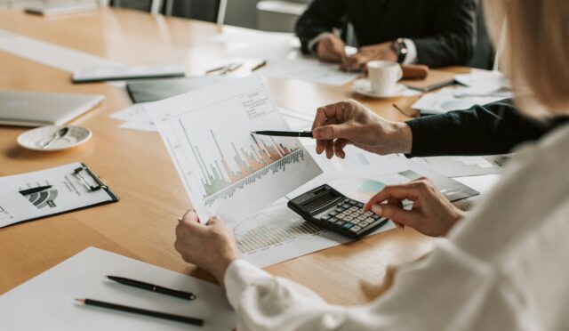 Professionals reviewing financial graphs and charts during a meeting.