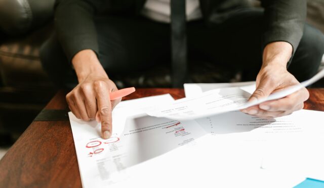 A businessman analyzing financial documents with important data and figures on a desk, ideal for business analytics and accounting themes.